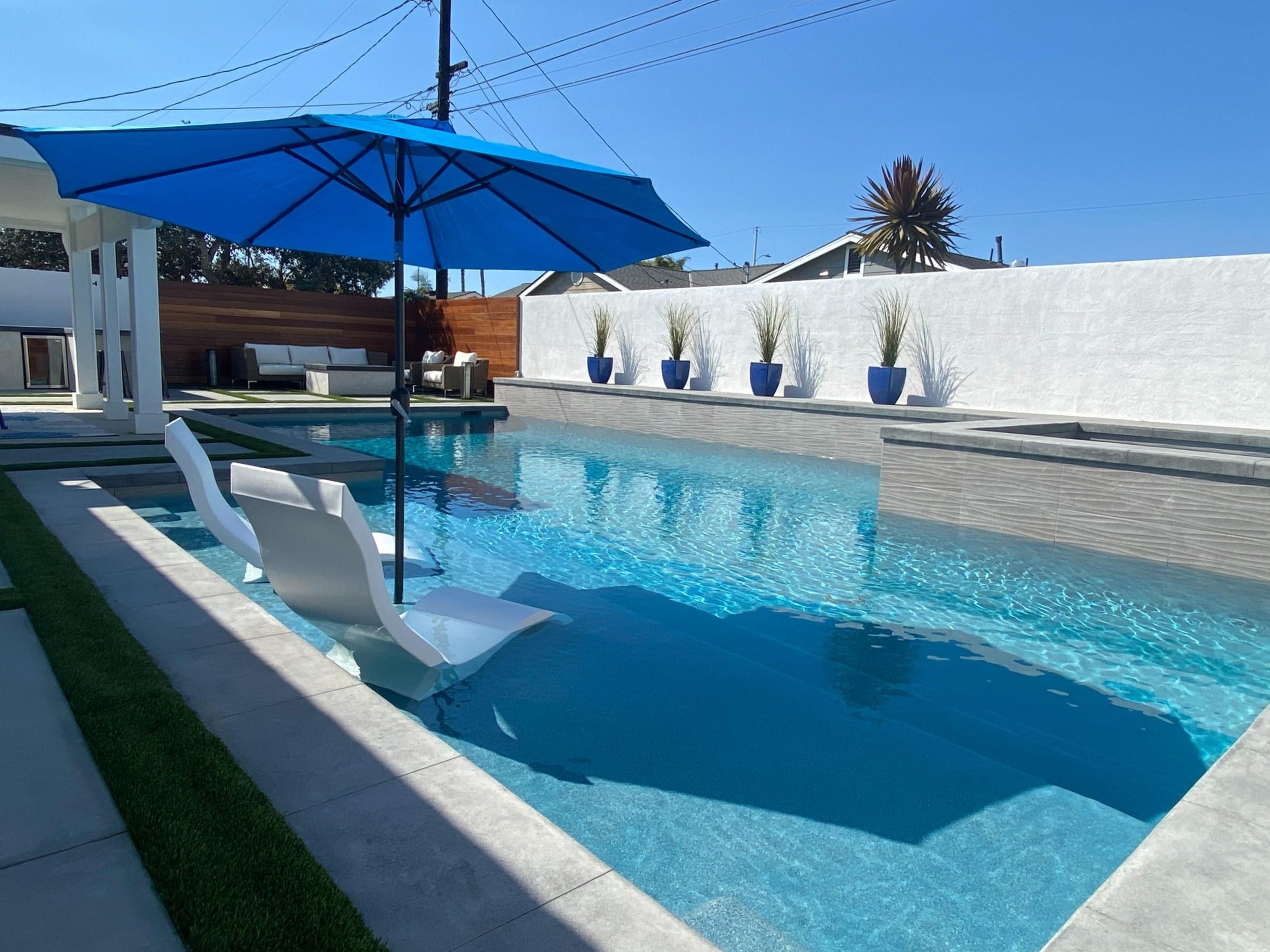 Luxury backyard pool with lounge chairs built by JSQ Improvements — Huntington Beach pool remodeler