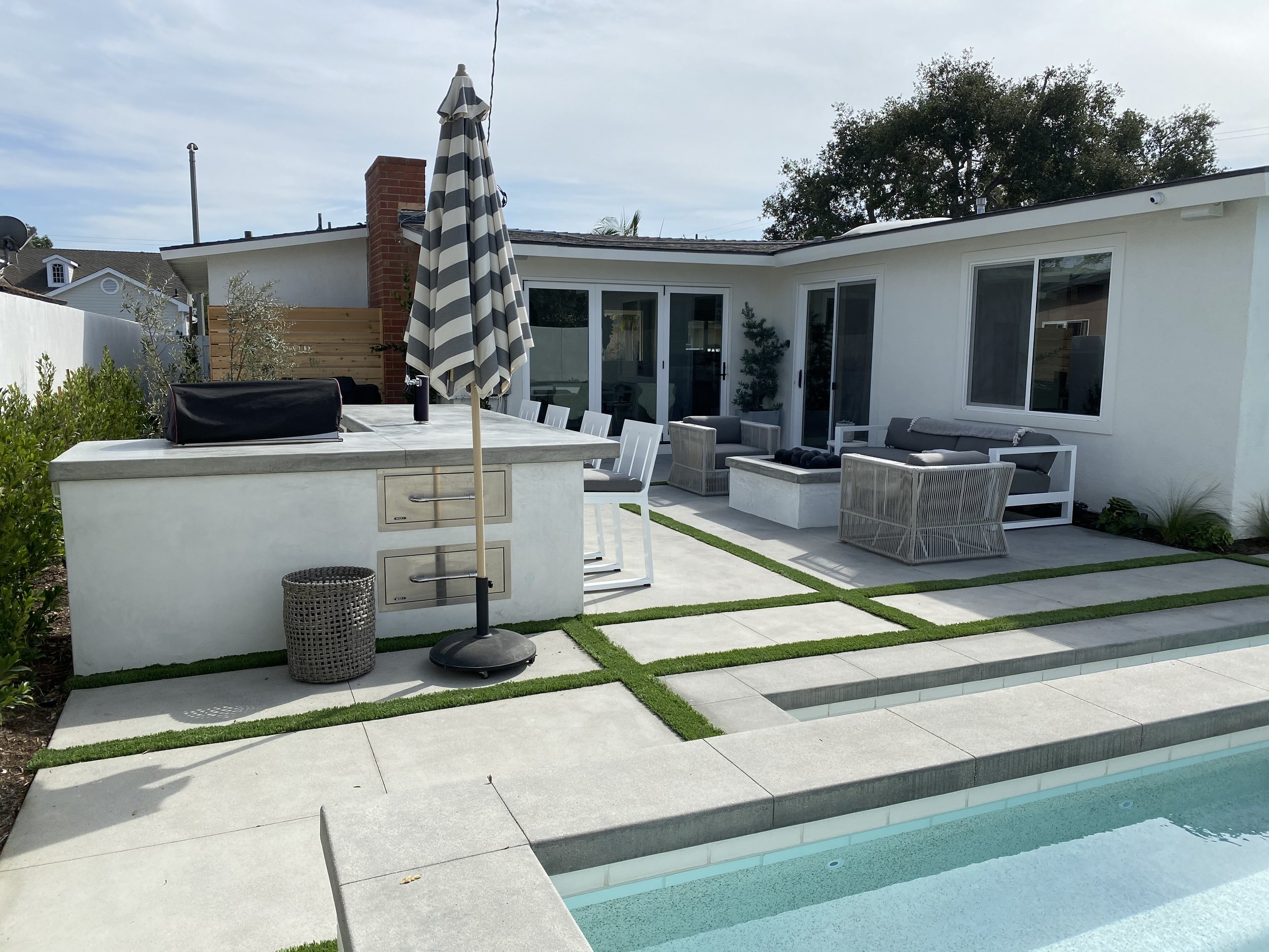 Outdoor living space with kitchen and fire pit — JSQ Improvements Huntington Beach pool contractor